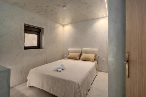 a bedroom with a bed with a stuffed animal on it at The Luxe Residence in episkopi-chania