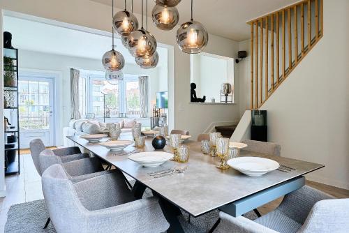 a dining room with a long table and chairs at Villa Duinbergen - Séjour Familial à Knokke-Heist in Knokke-Heist