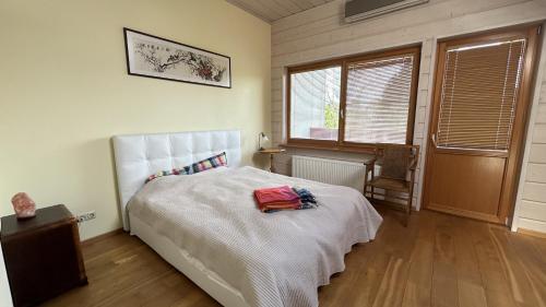a bedroom with a white bed with a red bag on it at Melluzi Seaside Residence in Jūrmala