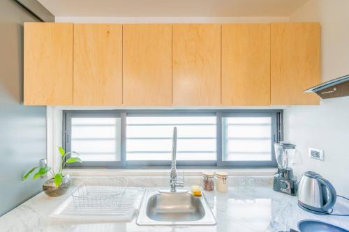 a kitchen with wooden cabinets and a counter top at Tokio Loft Loft Moderno en Centro de Durango in Durango