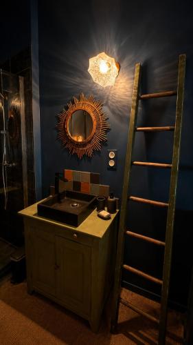 a bathroom with a sink and a mirror and a ladder at Studio Rétro in Tournus