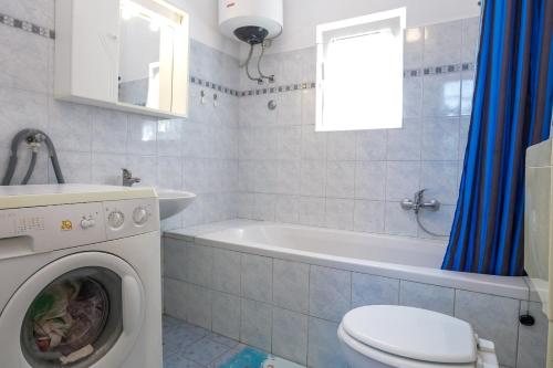 a bathroom with a washing machine and a tub at Holiday house Bruno in Savar