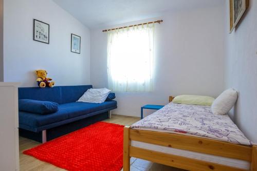 a bedroom with a blue couch and a red rug at Holiday house Bruno in Savar