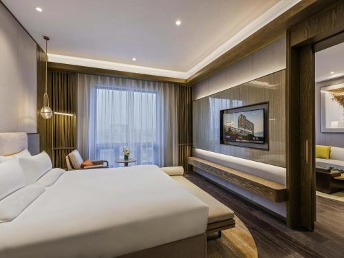 a hotel room with a bed and a desk at Novotel Shanxi Yuncheng in Yuncheng