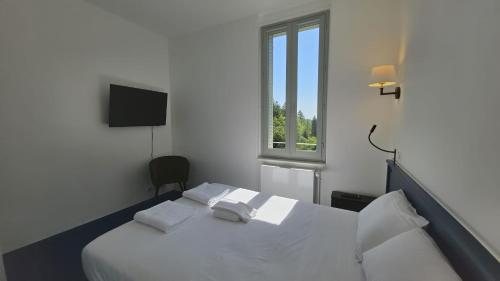 a bedroom with a white bed with two white pillows at L'hostellerie de la vallée in Gimel