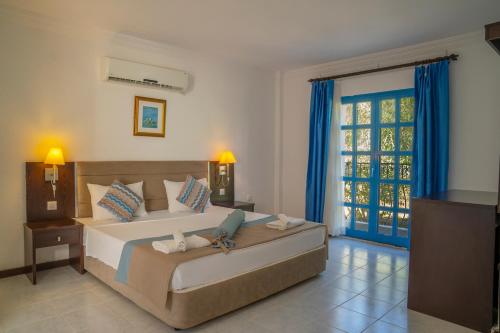 a bedroom with a bed with a laptop on it at Ladonia Hotels Zemda in Gümüşlük