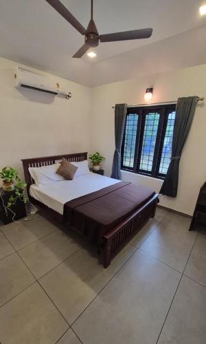 a large bed in a room with a large window at Casa Luminaria in Alleppey
