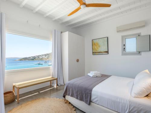 a bedroom with a bed and a view of the ocean at myMykonos villa II in Platis Gialos