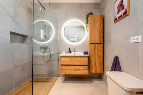 a bathroom with a sink and a shower with a mirror at Holiday Home Marija with pool in Buković