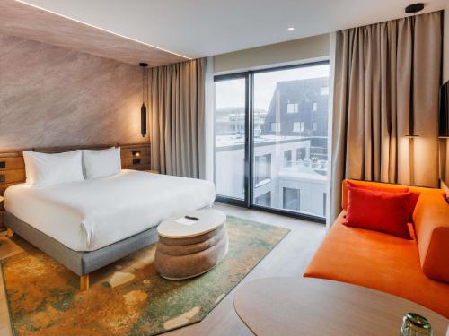 a hotel room with a bed and a couch at Novotel Tallinn in Tallinn