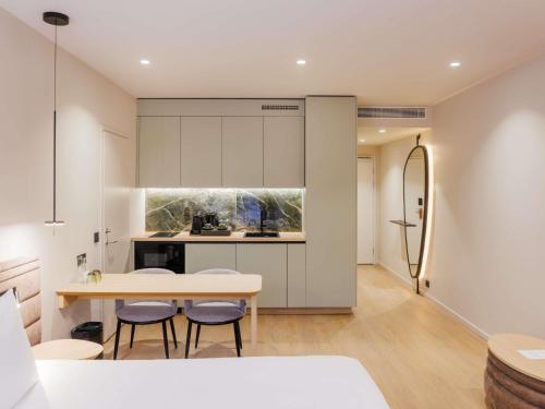 a kitchen with a table and chairs and a refrigerator at Novotel Tallinn in Tallinn