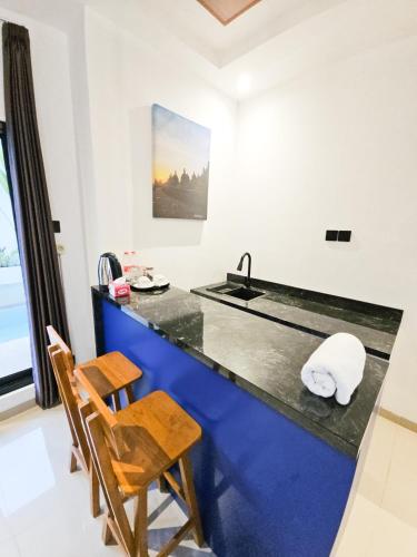 a kitchen with a counter with a sink and a chair at Lodjisvarga Villa Yogyakarta in Sleman