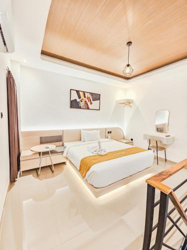 a bedroom with a bed and a desk and a tv at Lodjisvarga Villa Yogyakarta in Sleman