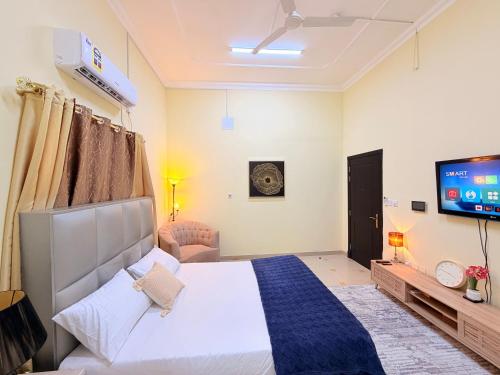 a bedroom with a large bed and a tv at Modern Studios Apartments in Juffair and Exhibition in Manama