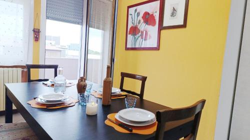a dining room table with plates and utensils on it at Dimora Euganea by Ca-Sa Check in Monselice