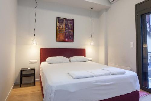 a bedroom with a large white bed with two pillows at Brand-New Spacious 3 Bd Apt in Piraeus in Piraeus