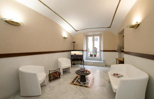 a living room with white chairs and a table at Hotel Priscilla in Rome