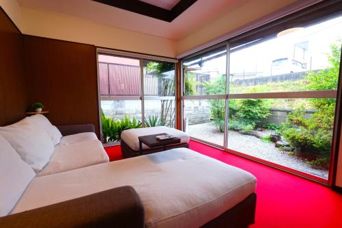a bedroom with a bed and a large window at YADOOR名張 -kominka- in Nabari
