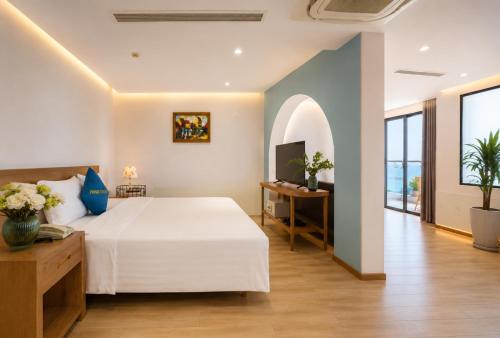a bedroom with a large white bed and a television at Prime New Hotel in Nha Trang