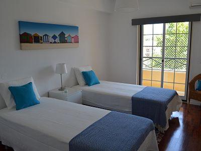 een hotelkamer met twee bedden en een raam bij Alegre Apartamento in Cascais