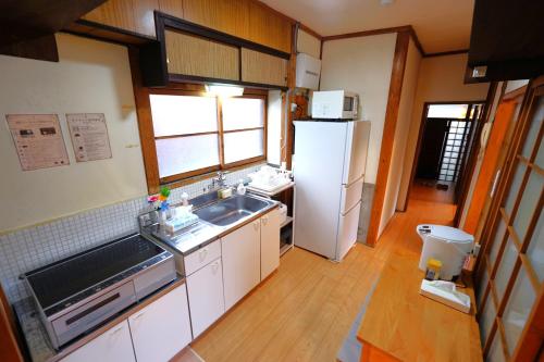 a kitchen with a sink and a refrigerator at YADOOR名張 -kominka- in Nabari