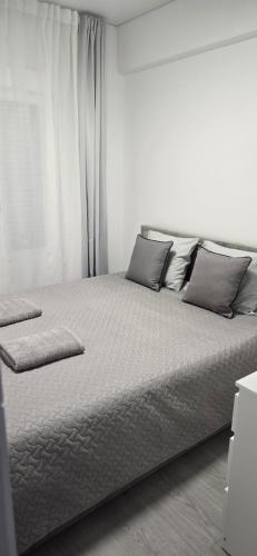 a white bedroom with a bed with pillows at La Romanilla Garden terrace in Roquetas de Mar