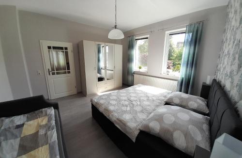a bedroom with a bed and two windows at Sandstein-Oase in Reinhardtsdorf