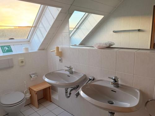 a bathroom with a sink and a toilet and a window at In & Out Boardinghaus in Stolberg