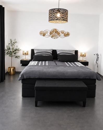 a bedroom with a large bed and a pendant light at Ferienhaus Schieferland in Müllenbach