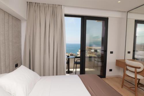 a bedroom with a bed and a view of the ocean at Safir Luxury Suites in Sarandë