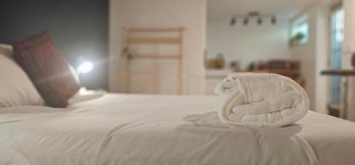 a white towel sitting on top of a bed at Hibiscus Suite - Private Studio Apartment in Rhinebeck Village in Rhinebeck