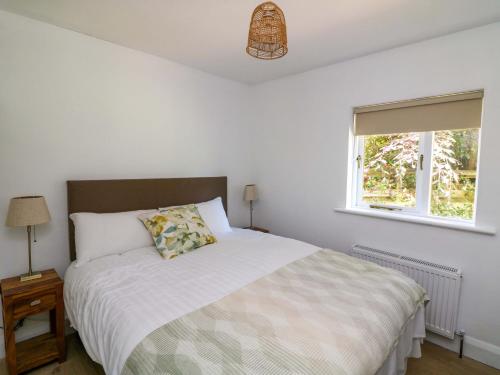 a bedroom with a bed and a window at The Mews Derrybawn in Glendarragh