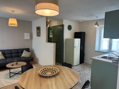 a kitchen and a living room with a table and a couch at Résidence le 1564 Vert in Roussillon en Isere