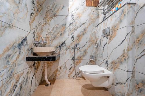 a bathroom with a toilet and a sink at Mangal Hotel & Resorts Pool in Udaipur