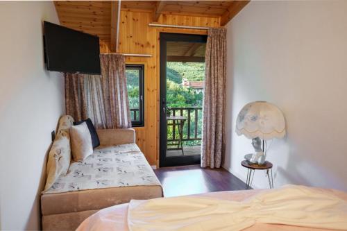 a bedroom with a bed and a sliding glass door at Shena The Farm Boutique in Mesopotam