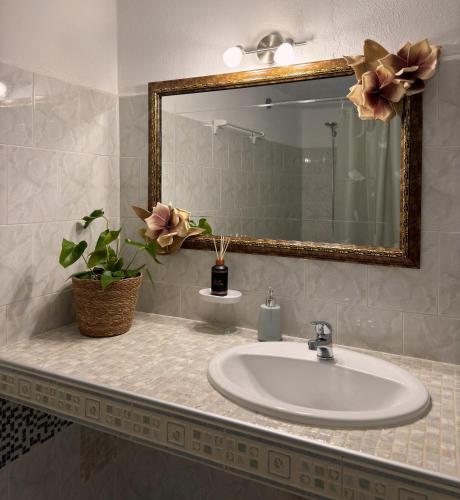 a bathroom with a sink and a mirror at The Olive Studio by Yannula Studios in Kámpos