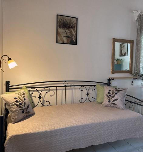 a bedroom with a bed with white sheets and a mirror at The Olive Studio by Yannula Studios in Kámpos