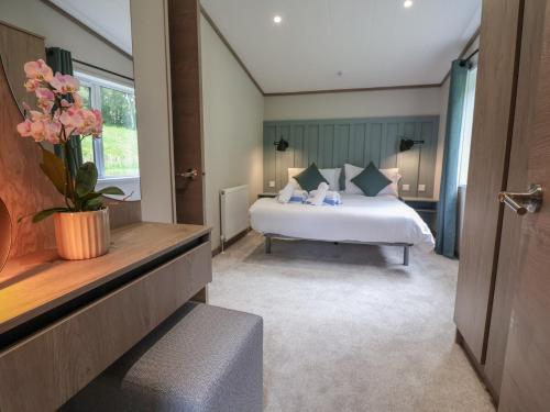 a bedroom with a bed and a vase of flowers at Cedar Lodge 2 Bedrooms with hot tub in Northwich