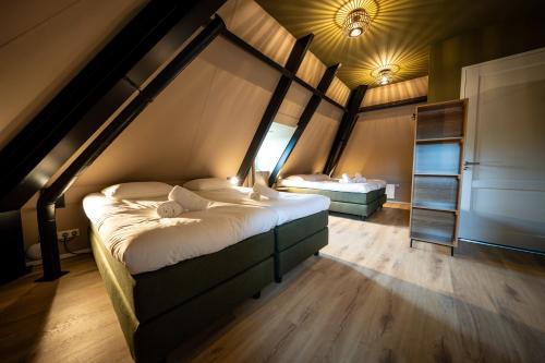 a bedroom with two beds in a attic at Othmar 't Lagerhuys - Groepsaccommodatie in Ootmarsum