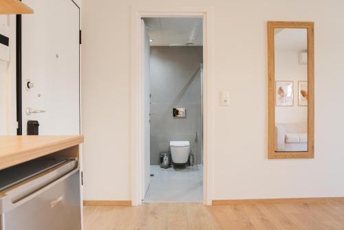 a bathroom with a toilet and a mirror at Urban Liv Athens in Athens