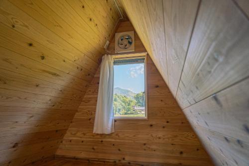 a small attic window in a wooden cabin at 自然満喫 野上平ロッジ in Kirishima
