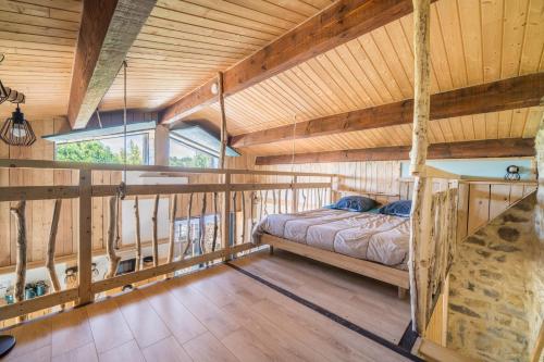 a bedroom in a log cabin with a bed in it at Le Cocon - Grospierres in Grospierres