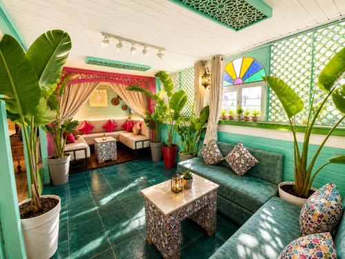 a living room with green furniture and plants at Riad Verus in Fez
