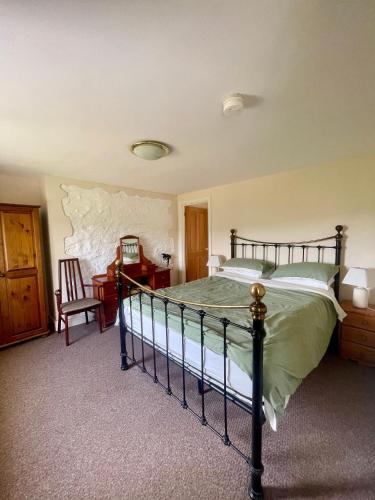 a bedroom with a bed and a desk and a chair at Merlin Cottages in Llandovery