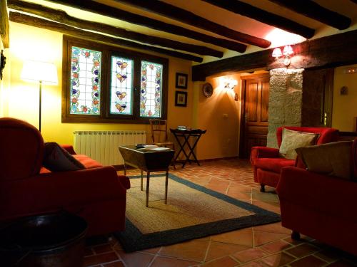 a living room with red furniture and stained glass windows at El Lagar del Vero in Huerta de Vero
