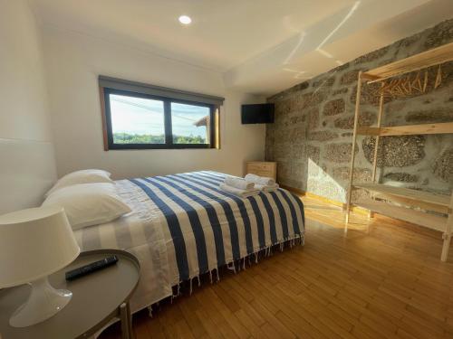 a bedroom with a bed and a desk and a window at Quinta do Eirô in Fonte Arcada