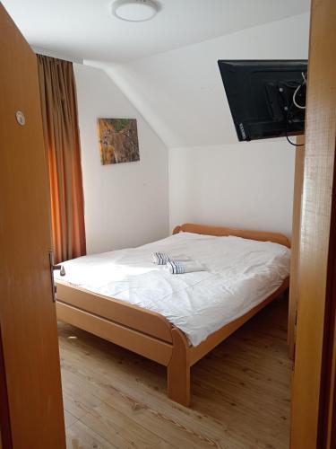 a small bedroom with a bed with white sheets at Vila Cezar in Gornja Toplica