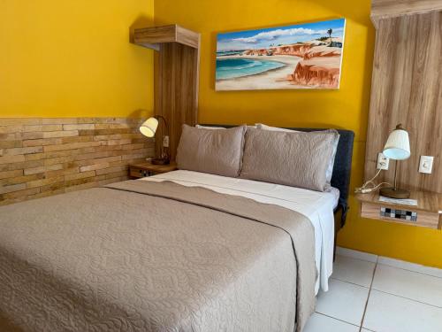 a bedroom with a bed and a yellow wall at Pousada Presidente Hotel in Canoa Quebrada