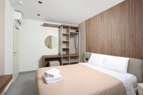 a bedroom with a bed with towels on it at ELYSIAN luxury apartments in Paliouri