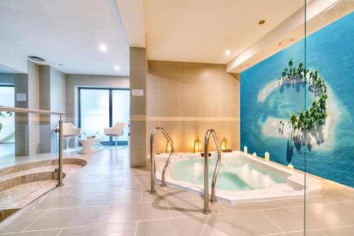 a bathroom with a tub with a painting on the wall at ATRIUM Sarbinowo Na Fali in Sarbinowo